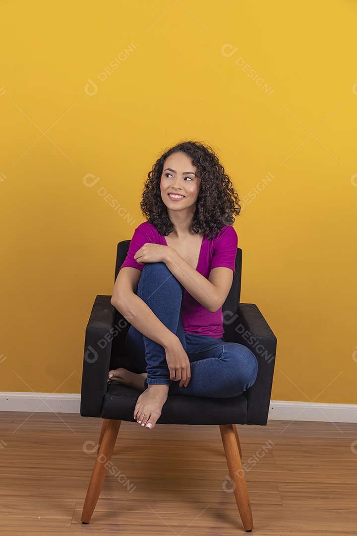 Mulher jovem cabelo cacheado sobre fundo amarelo