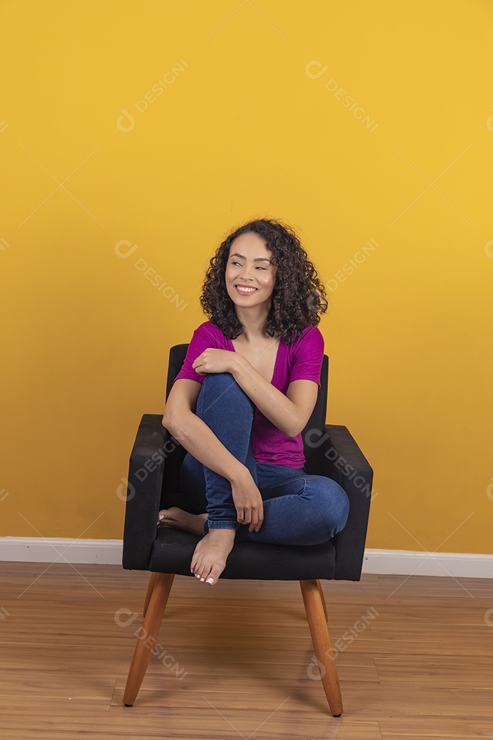 Mulher jovem cabelo cacheado sobre fundo amarelo