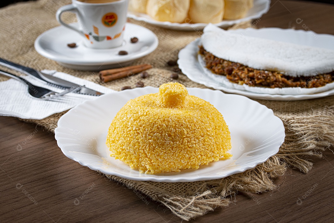 Cuscuz de milho sobre prato em uma mesa de madeira