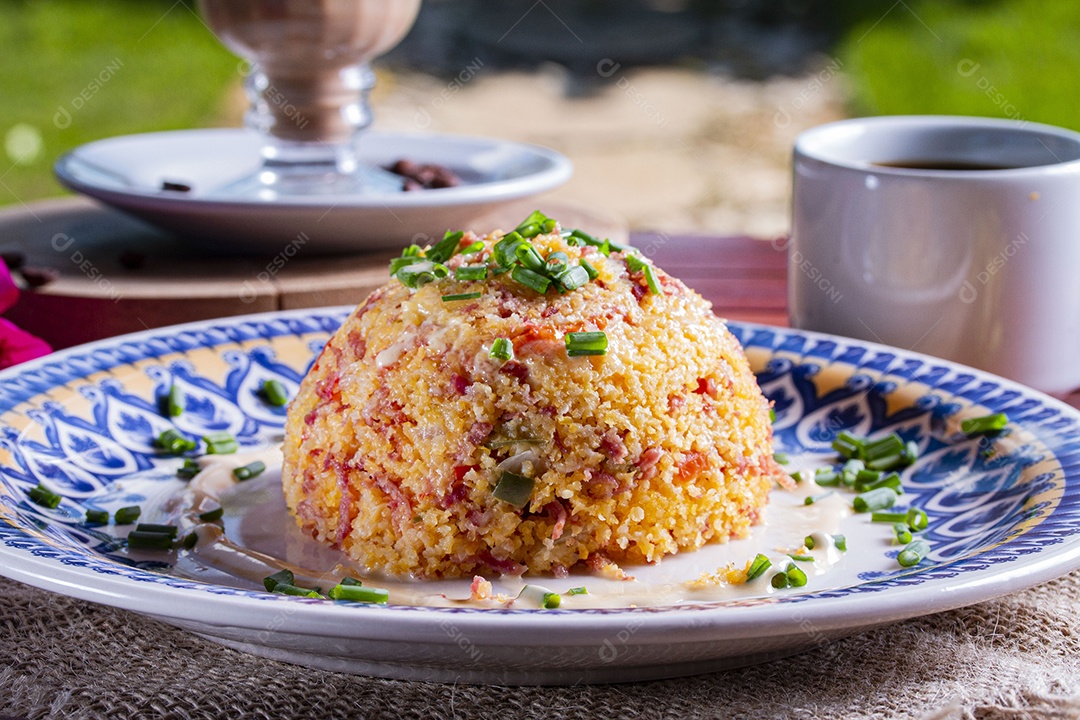 Cuscuz recheado sobre prato em uma mesa de madeira