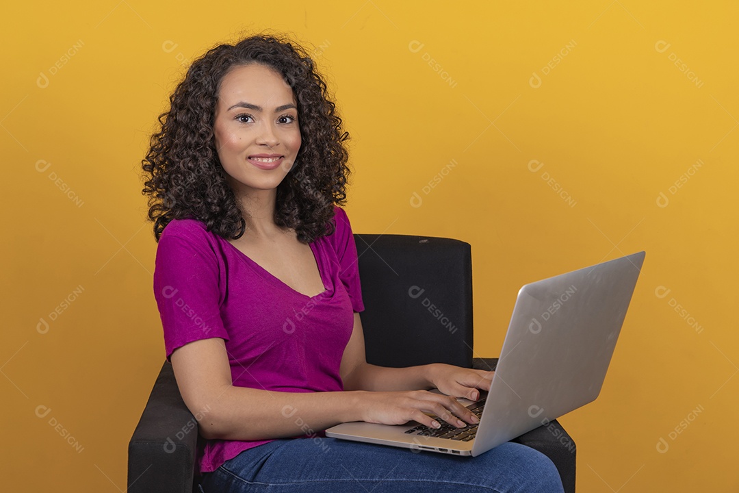 Mulher jovem cabelo mexendo notebook cacheado sobre fundo amarelo