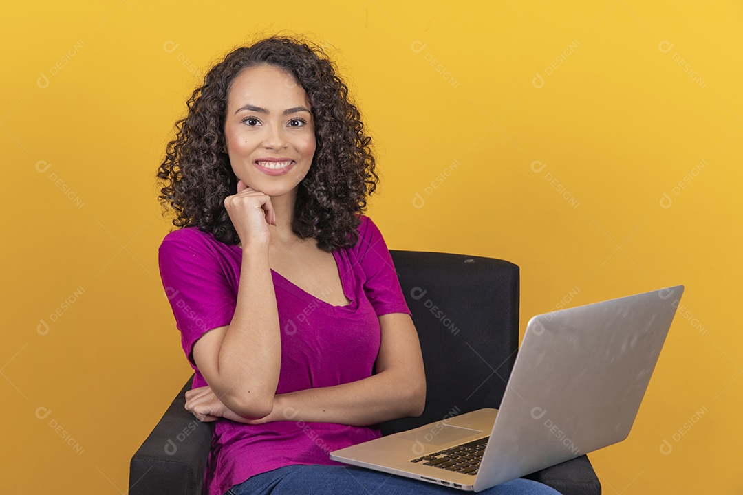 Mulher jovem cabelo mexendo notebook cacheado sobre fundo amarelo