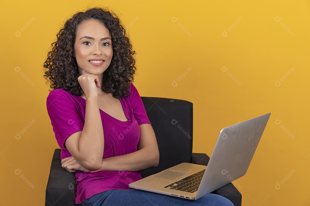 Mulher jovem cabelo mexendo notebook cacheado sobre fundo amarelo
