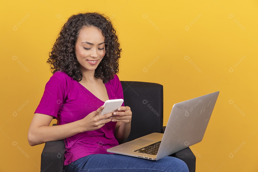 Mulher jovem cabelo mexendo notebook cacheado sobre fundo amarelo
