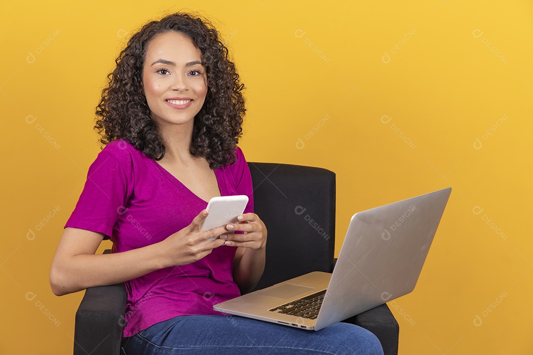 Mulher jovem cabelo mexendo notebook cacheado sobre fundo amarelo