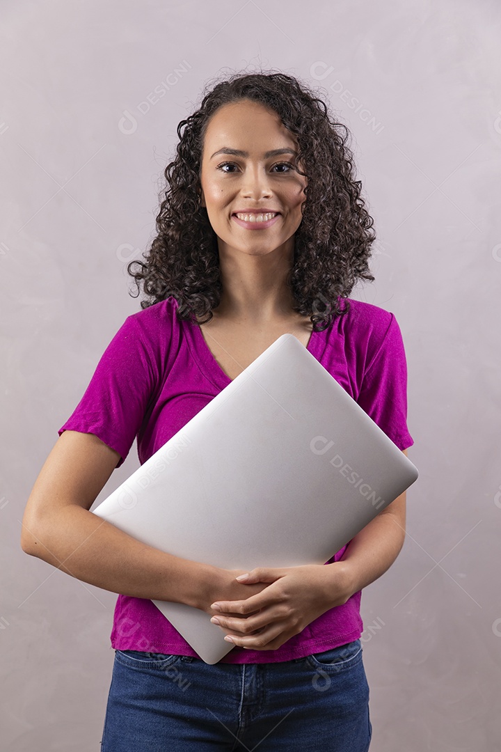 Mulher jovem cabelo mexendo notebook cacheado sobre fundo cinza