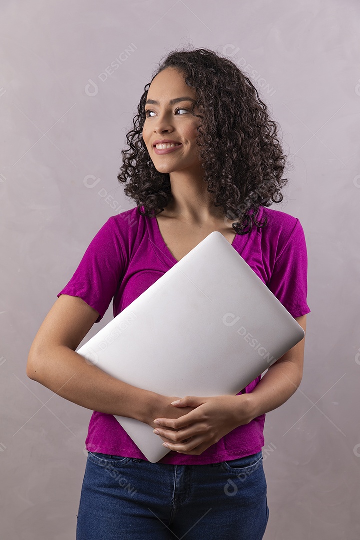 Mulher jovem cabelo mexendo notebook cacheado sobre fundo cinza