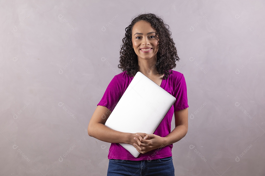 Mulher jovem cabelo mexendo notebook cacheado sobre fundo cinza