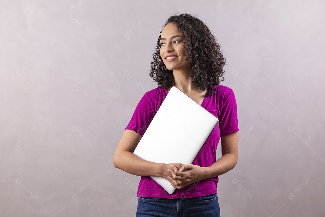 Mulher jovem cabelo mexendo notebook cacheado sobre fundo cinza