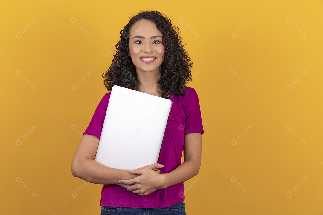 Mulher jovem cabelo mexendo notebook cacheado sobre fundo amarelo