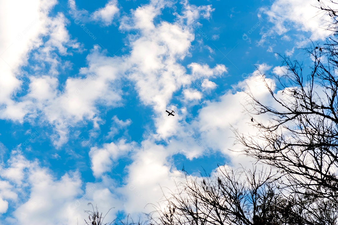 Céu azul com a silhueta de um avião voando.