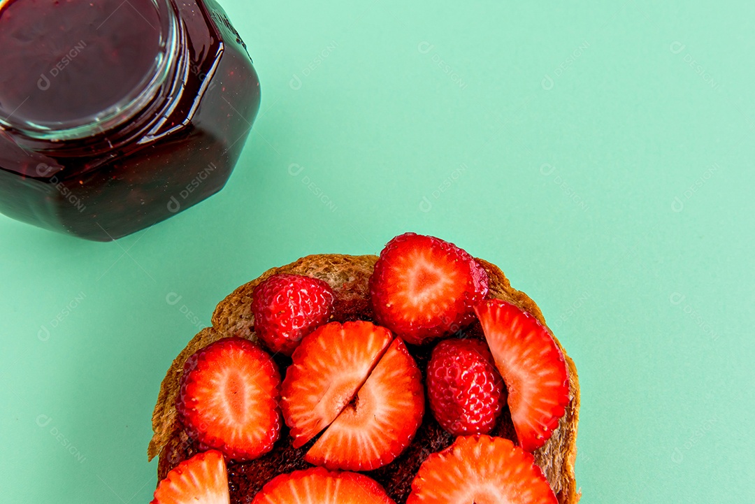 Pão com morangos e geleia de morango em um fundo verde