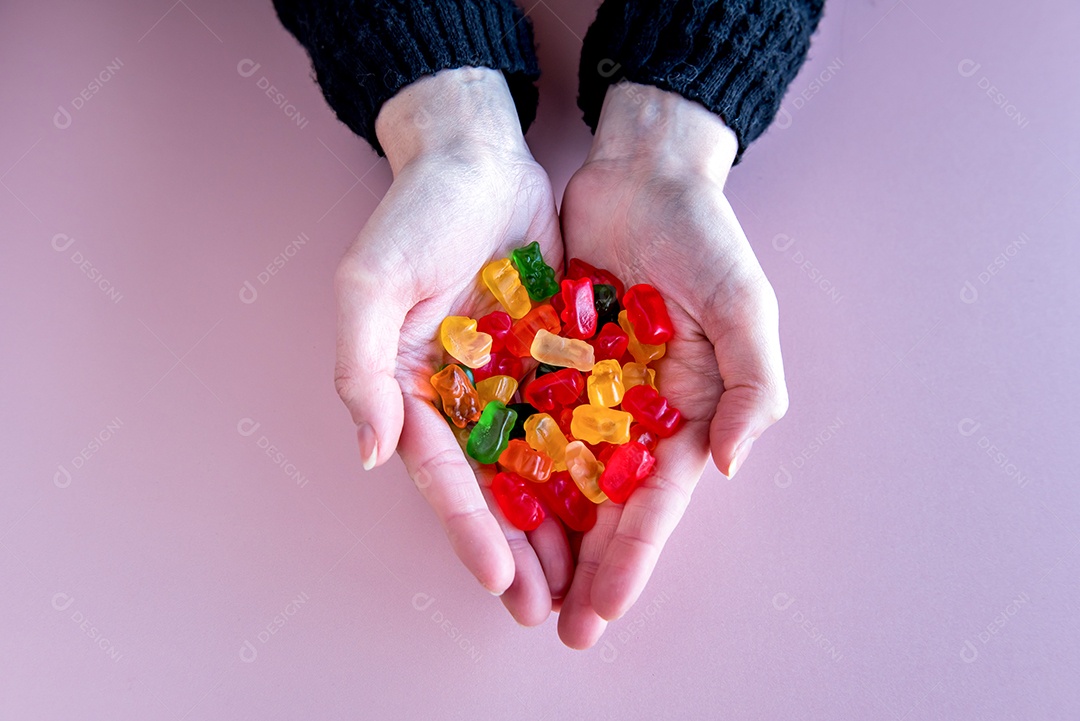 Mãos femininas segurando doces de ursinho de pelúcia