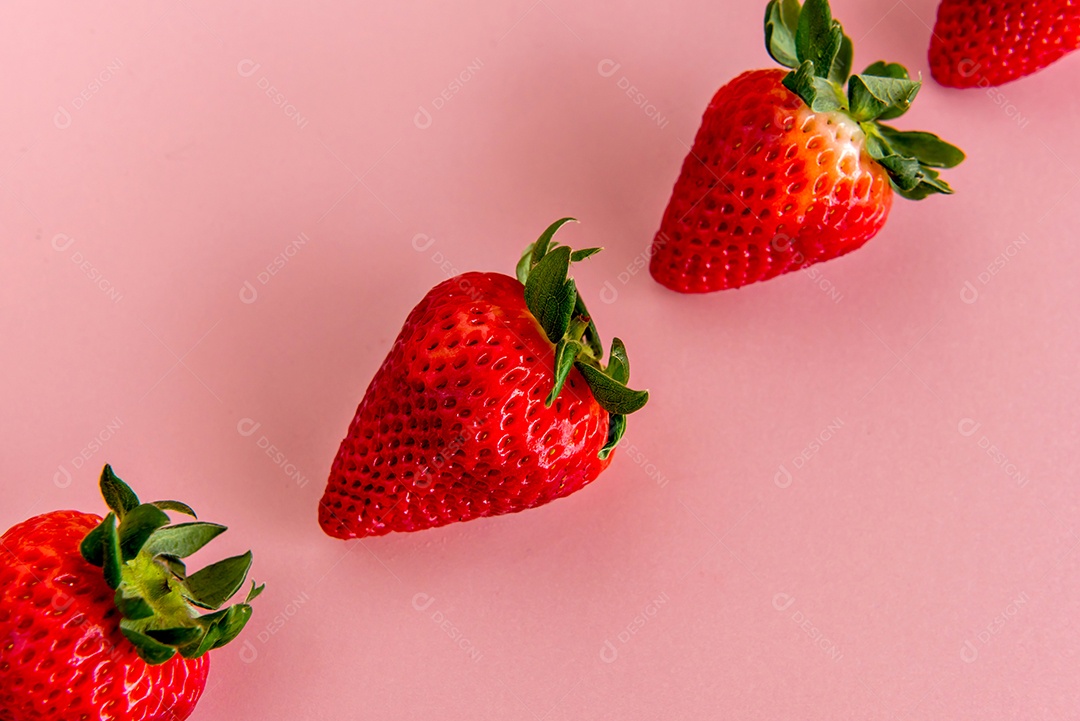 Morangos em fundo rosa.