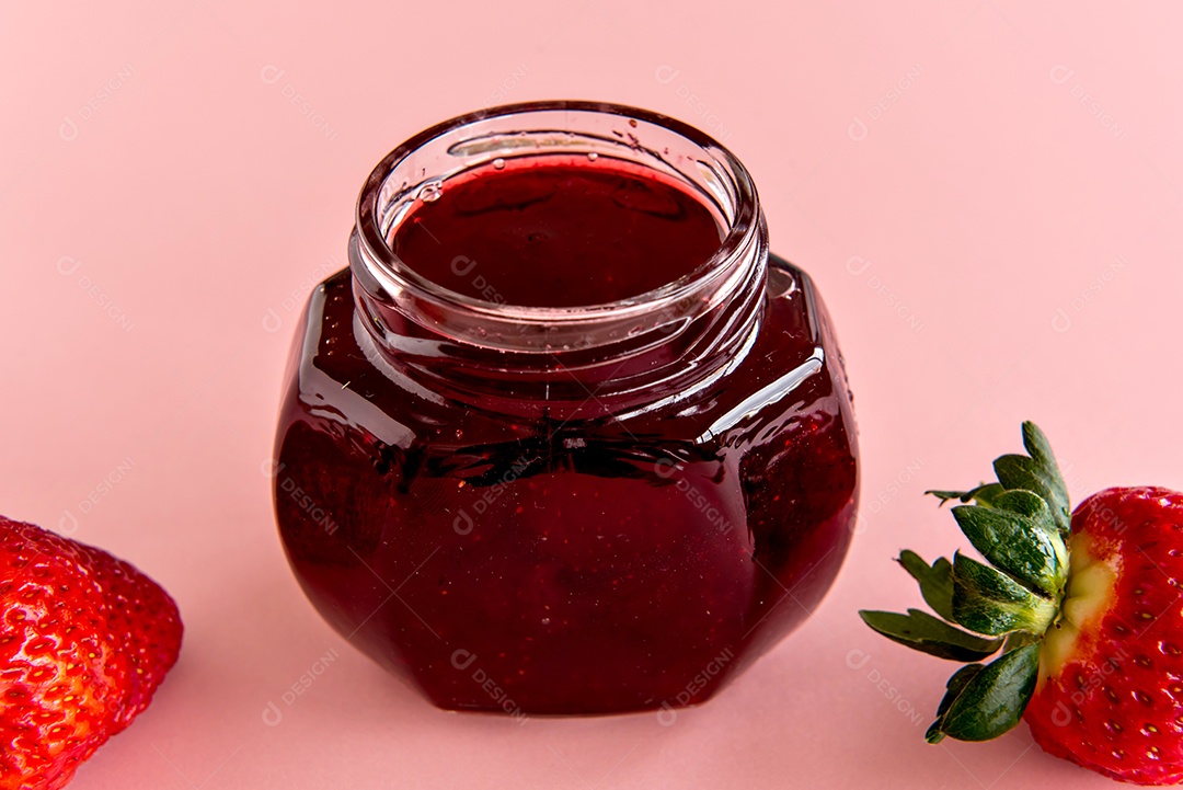 Geleia de morango e morangos em fundo rosa.