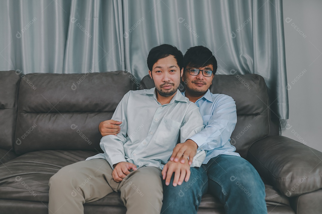 Feliz casal masculino homossexual passando tempo juntos em sofás dentro de suas casas. Feliz juntos conceito.