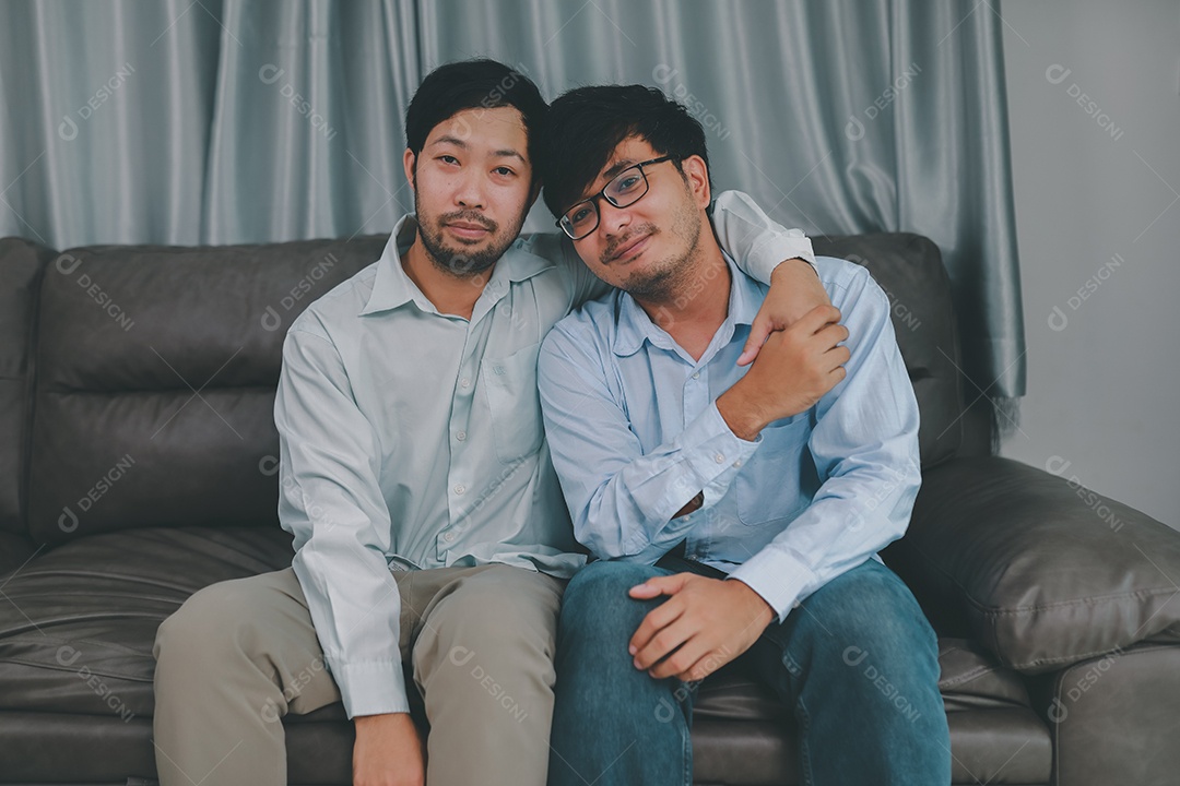 Feliz casal masculino homossexual passando tempo juntos em sofás dentro de suas casas. Feliz juntos conceito.