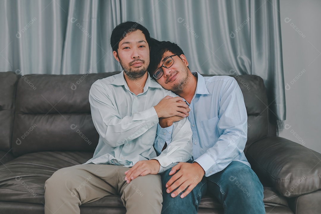 Feliz casal masculino homossexual passando tempo juntos em sofás dentro de suas casas. Feliz juntos conceito.