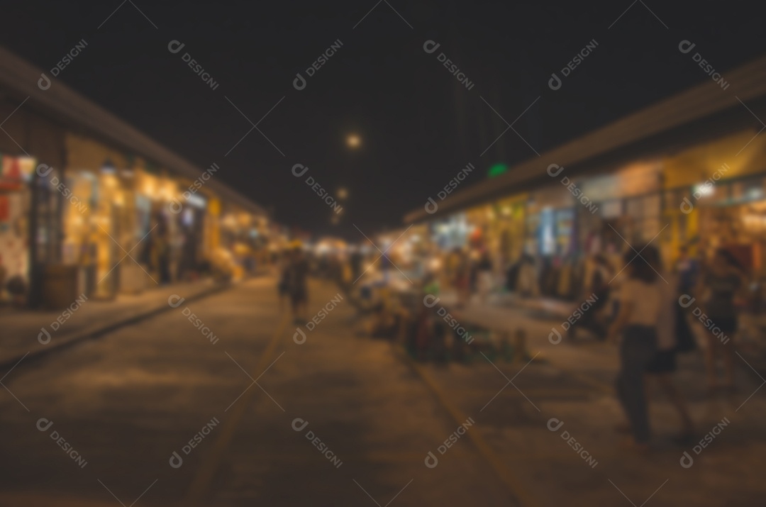 Pessoas desfocadas andando no mercado noturno.