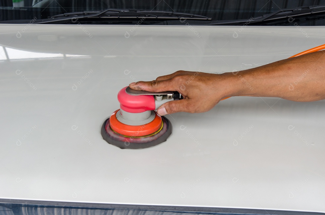 Homens polido cera no capô do carro branco.