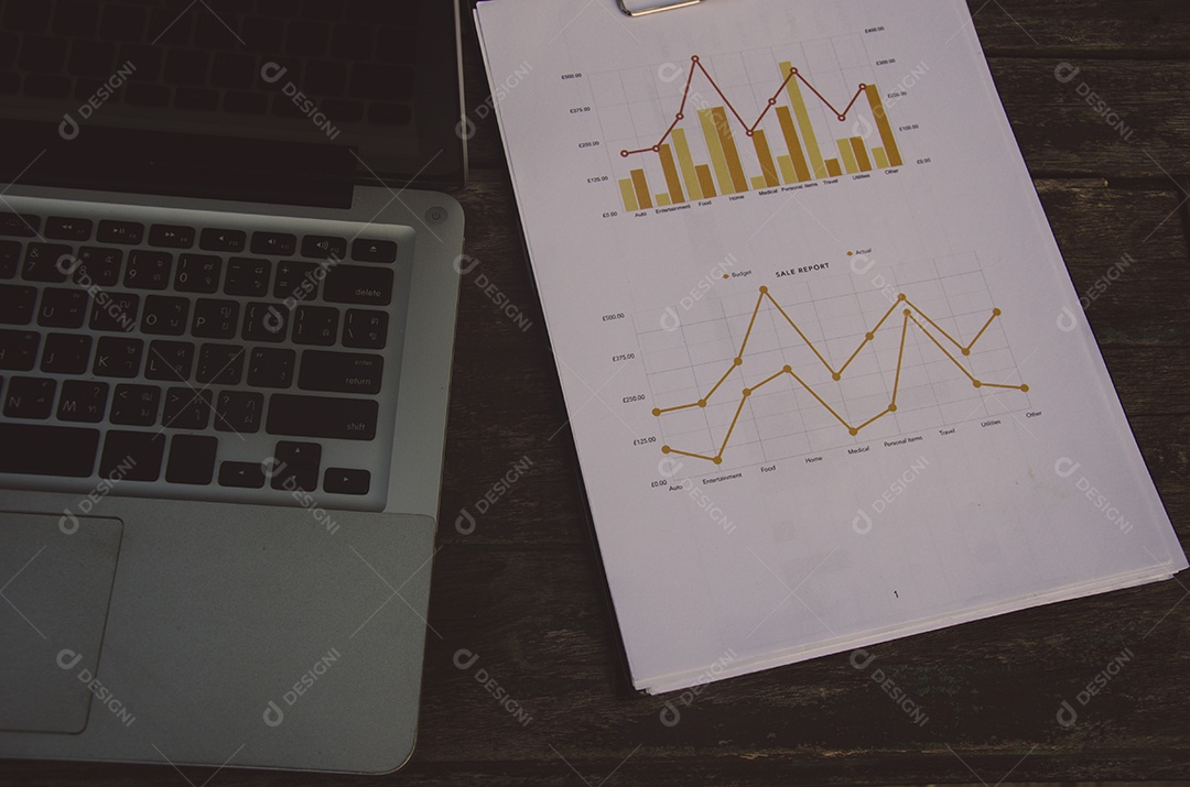 Gráfico financeiro com laptops de computador em madeiras de mesa.