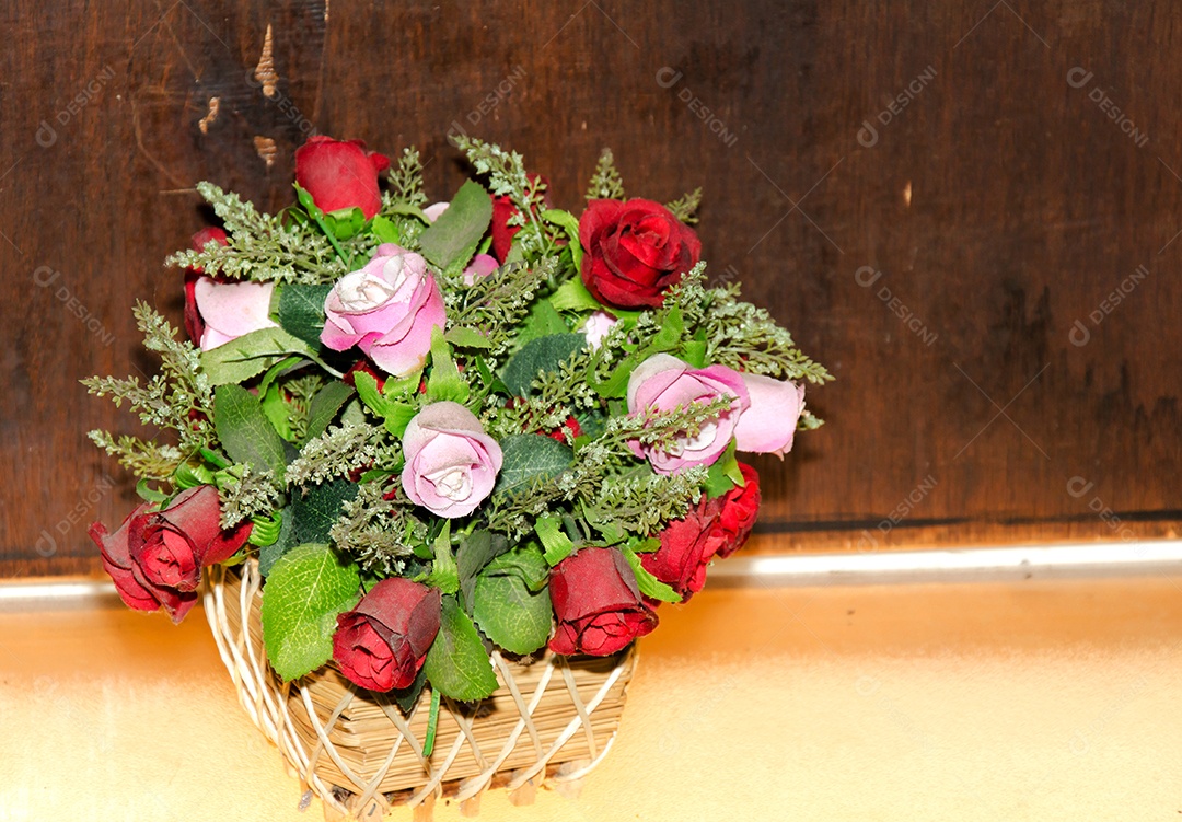 Rosas vermelhas e cor de rosa em uma cesta de madeira.