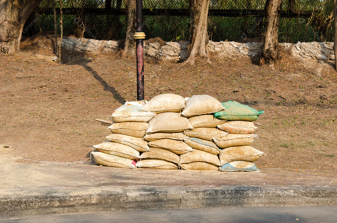 Os sacos de areia estão empilhados no chão.