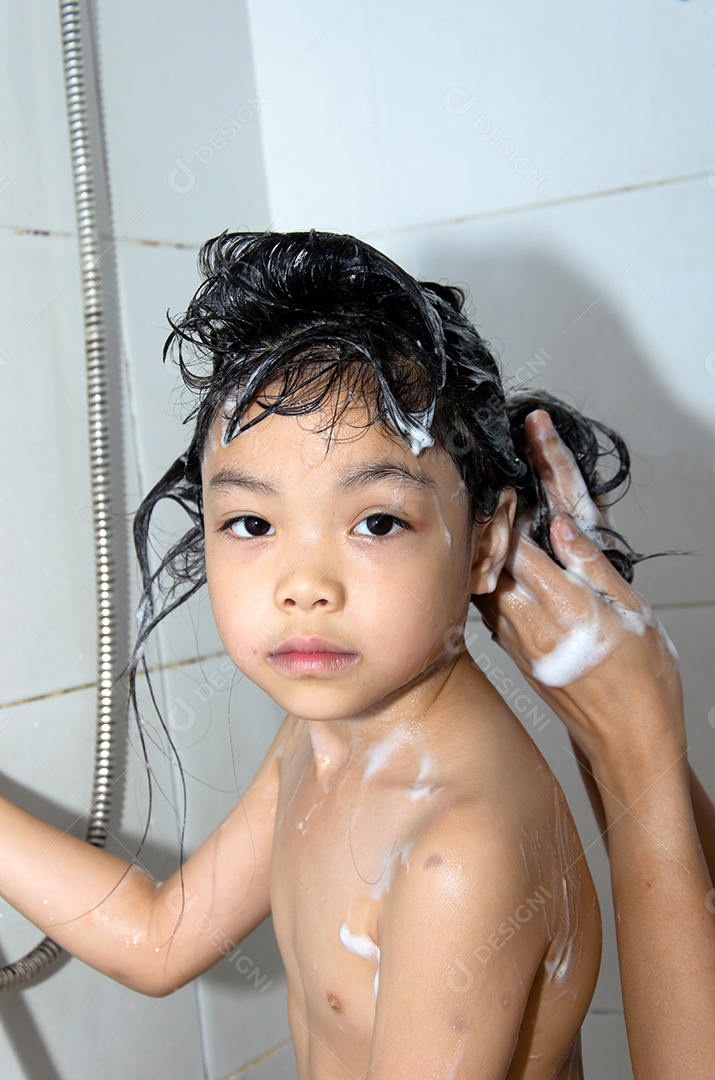 Garota asiática lavando o cabelo no banheiro.