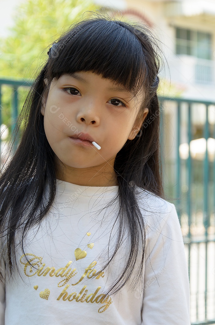 Menina asiática comendo pirulito