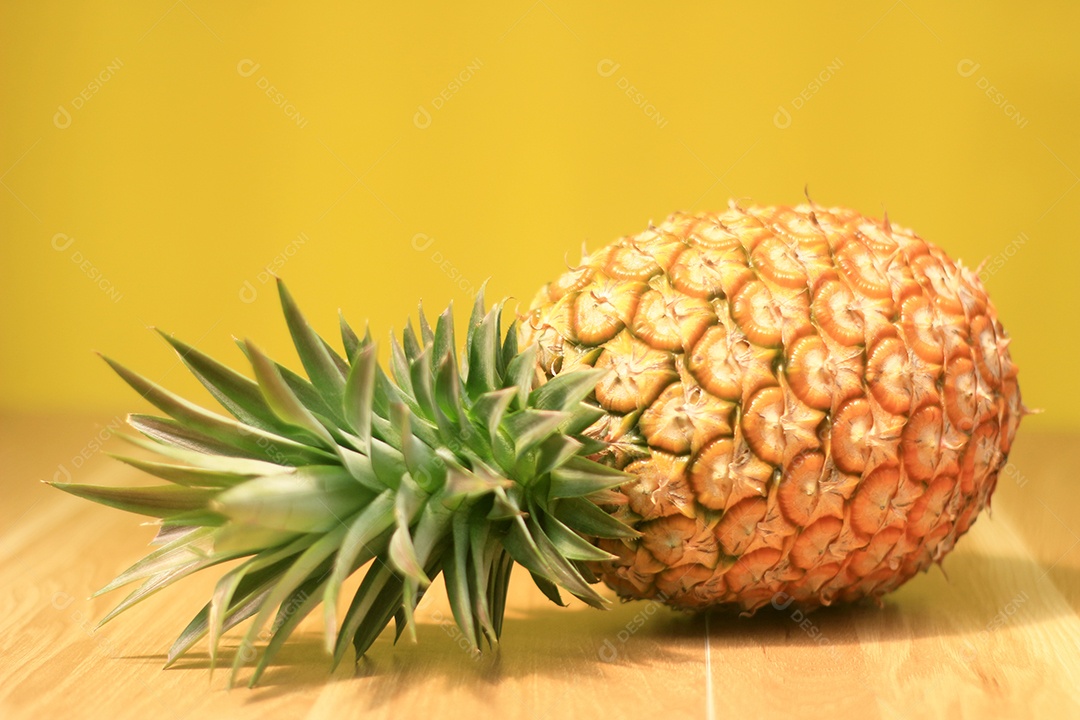 Abacaxi maduro em um fundo amarelo de madeira