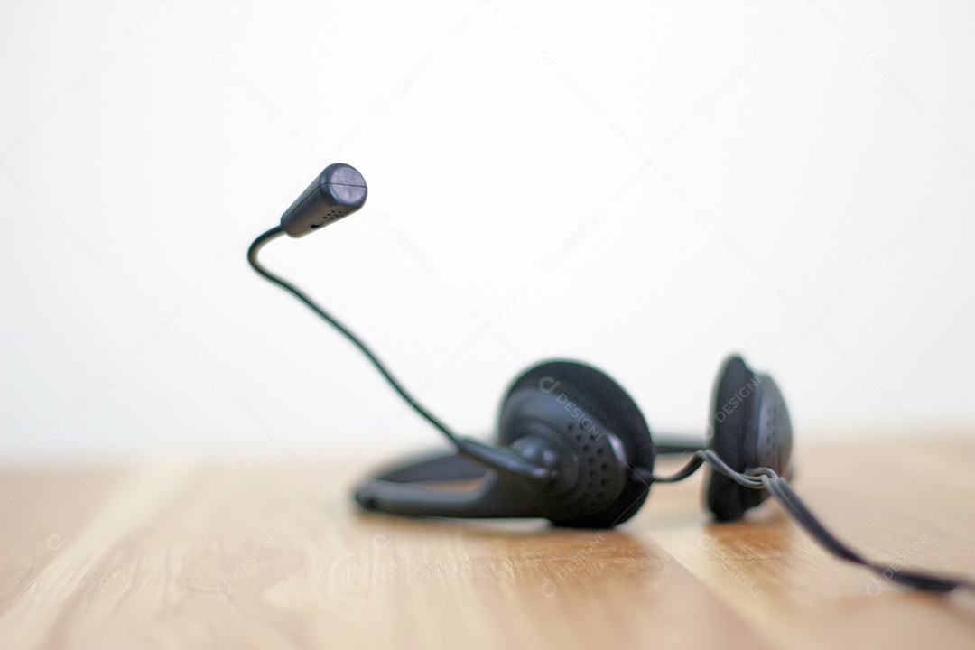 Espaço de trabalho com fone de ouvido e equipamentos de escritório em fundo de mesa de madeira