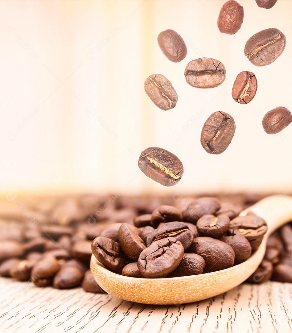 Grãos de café na colher de pau sobre mesa madeira