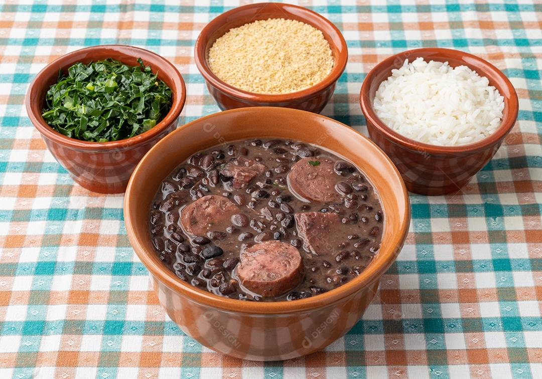 Feijoada típica brasileira com couve, arroz e farofa.