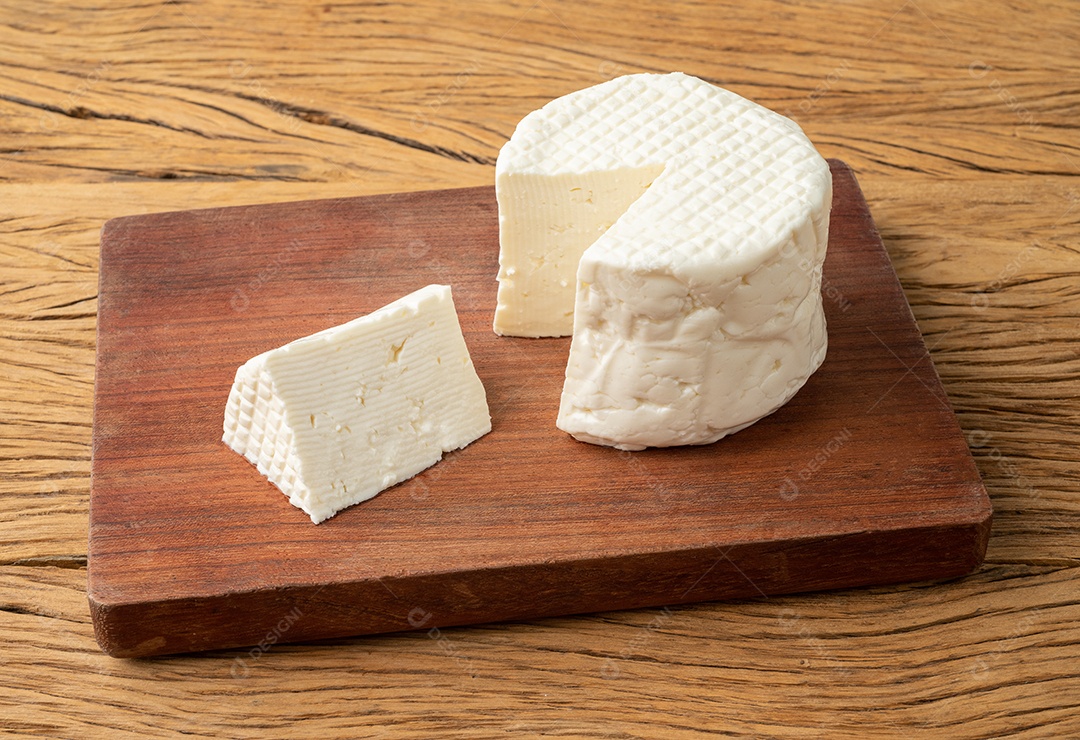 Queijo fresco, queijo branco fresco típico brasileiro com fatia sobre mesa de madeira.
