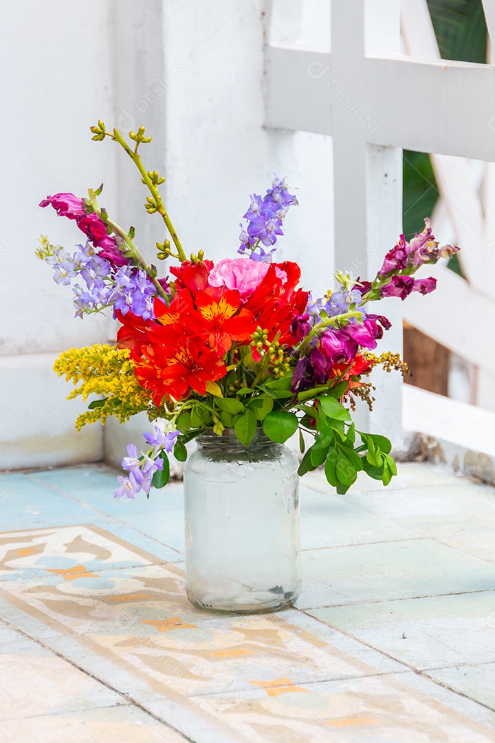 pote de vidro usado como vaso com várias flores no Rio de Janeiro.