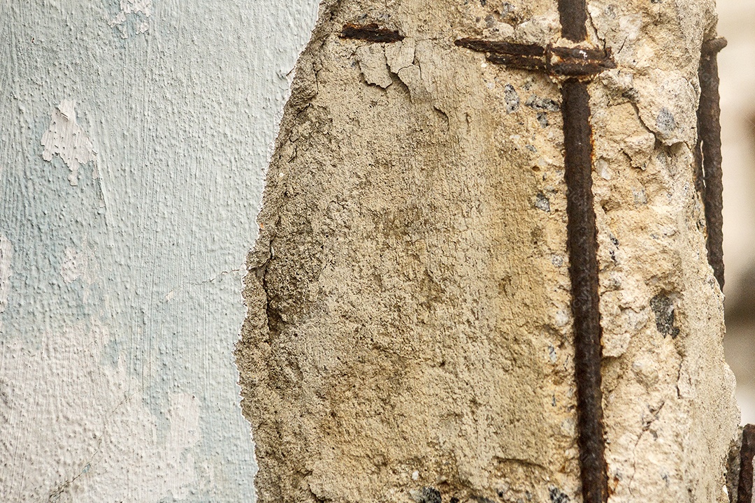 parede de cor verde água quebrada com estrutura de vergalhões mostrando no Brasil.