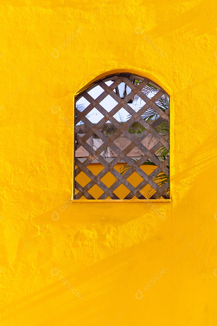 janela de madeira em uma parede amarela no Rio de Janeiro.