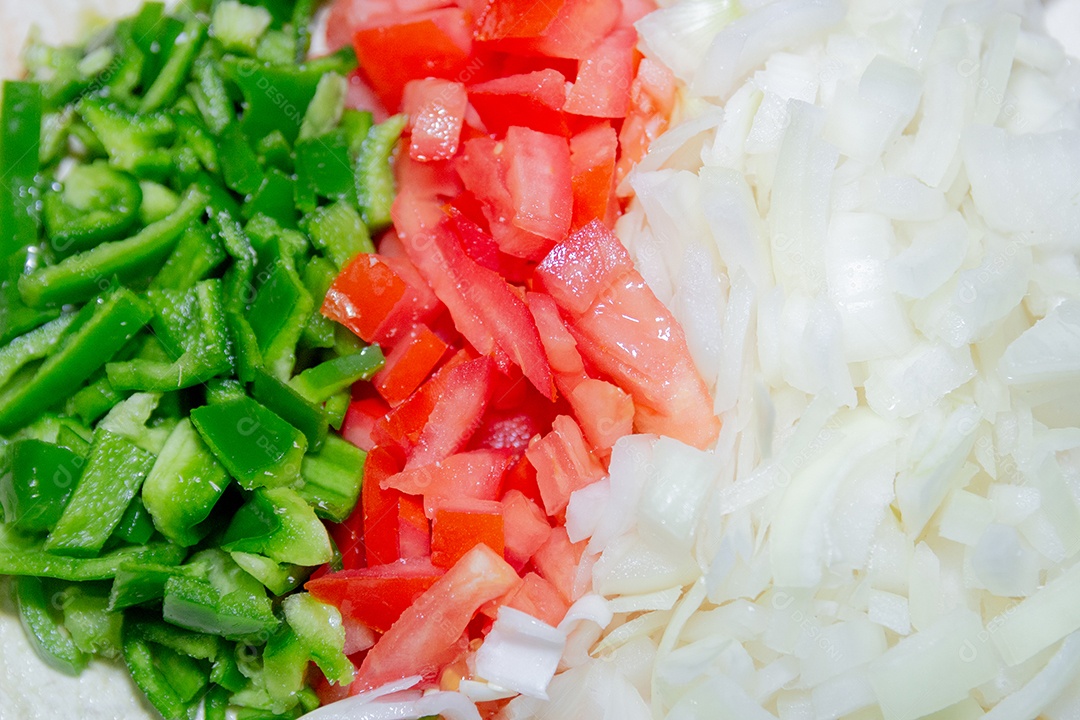 pimentão picado, tomate e cebola em uma mesa.