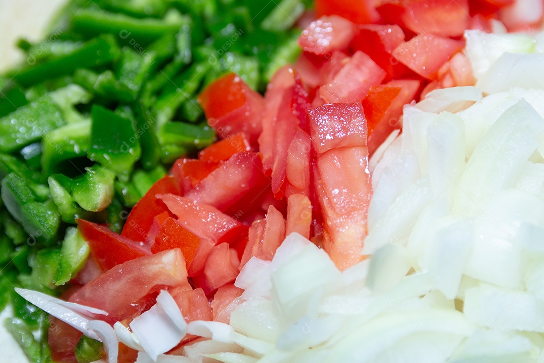 pimentão picado, tomate e cebola em uma mesa.