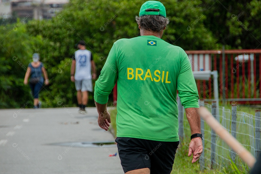 pessoa andando com uma camisa verde escrita brasil com letras amarelas no rio de janeiro brasil.
