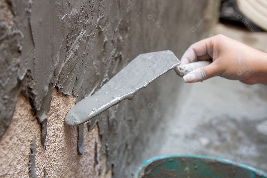 mulher com balde despejando cimento em uma parede no Rio de Janeiro Brasil.
