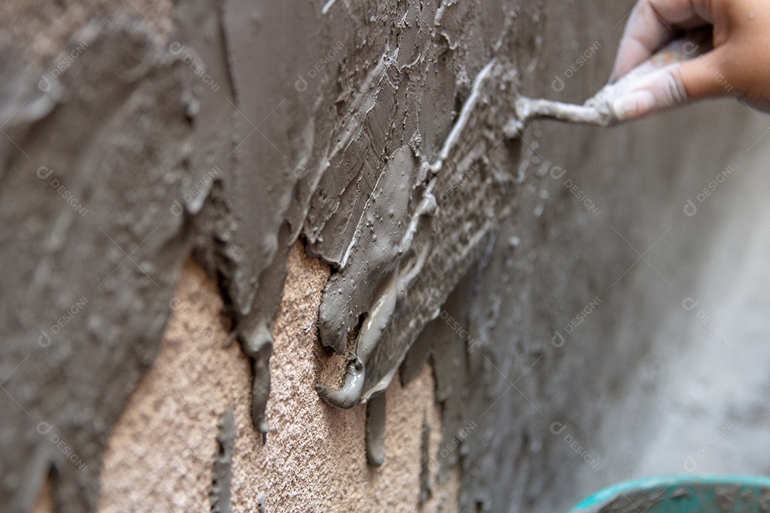 mulher com balde despejando cimento em uma parede no Rio de Janeiro Brasil.