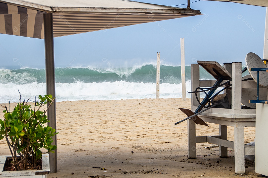 grande onda quebrando na praia do leblon com a aparência de um quiosque em primeiro plano no rio de janeiro Brasil.