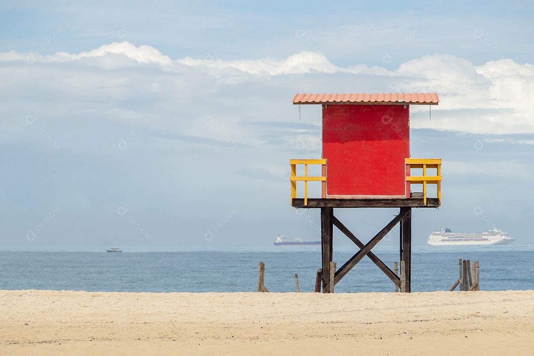 posto de salva-vidas vermelho na praia de copacabana com o mar ao fundo e o céu azul no rio de janeiro Brasil.