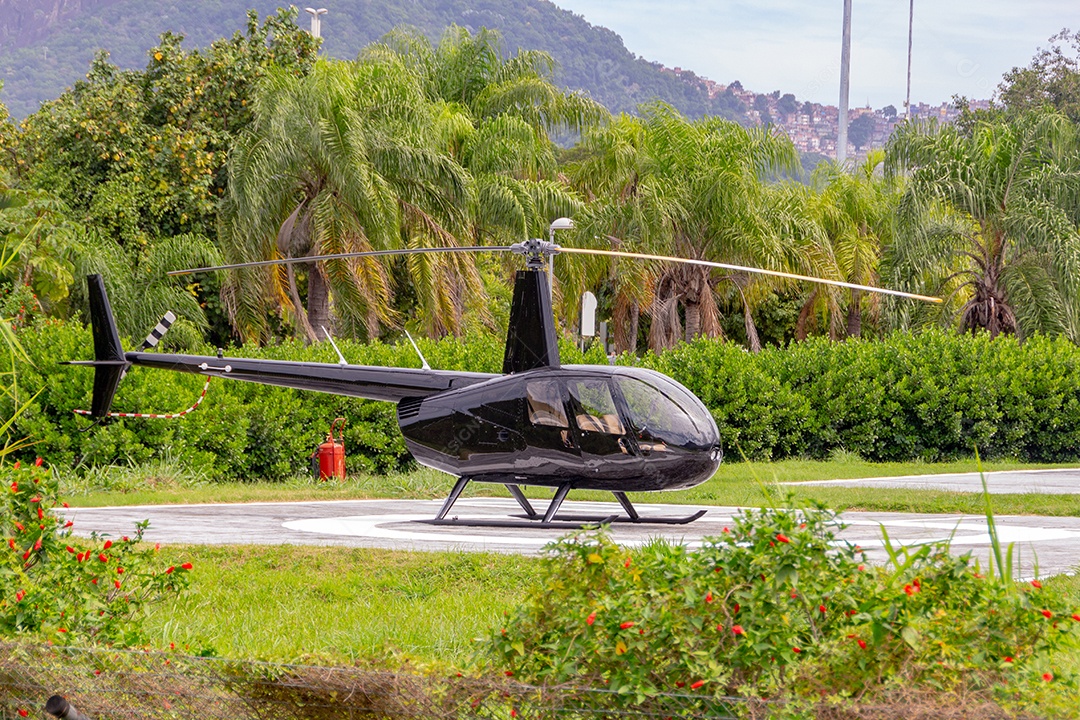 helicóptero preto modelo R44 raven ll no rio de janeiro brasil.