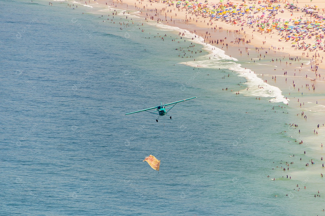 pequeno avião sobrevoando a praia de copacabana no Rio de Janeiro Brasil.