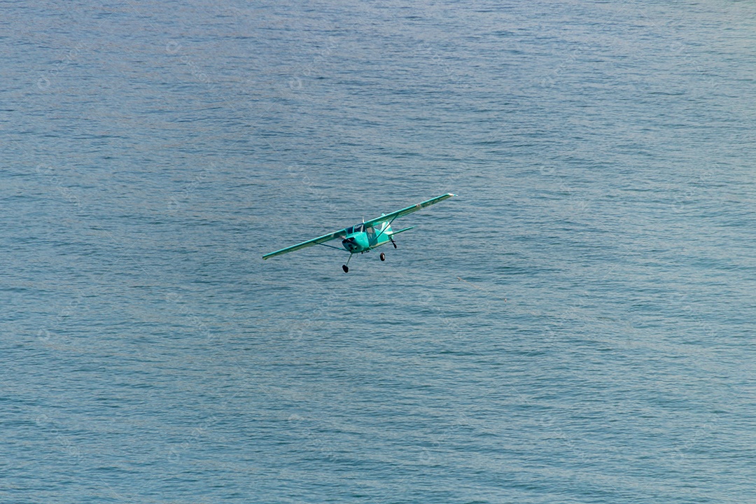 pequeno avião sobrevoando a praia de copacabana no Rio de Janeiro Brasil.