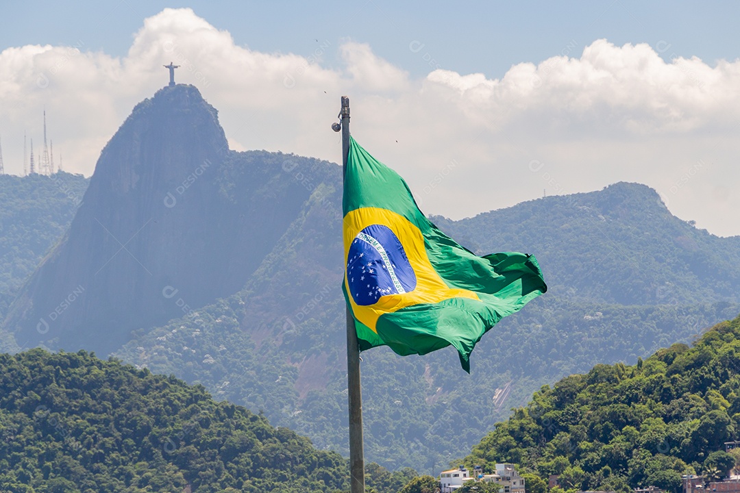 bandeira do brasil com imagem de cristo redentor ao fundo no rio de janeiro brasil.