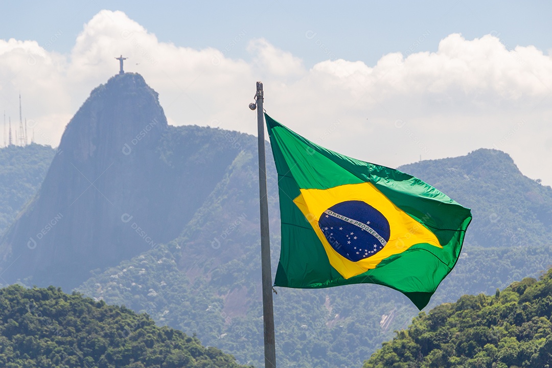 bandeira do brasil com imagem de cristo redentor ao fundo no rio de janeiro brasil.