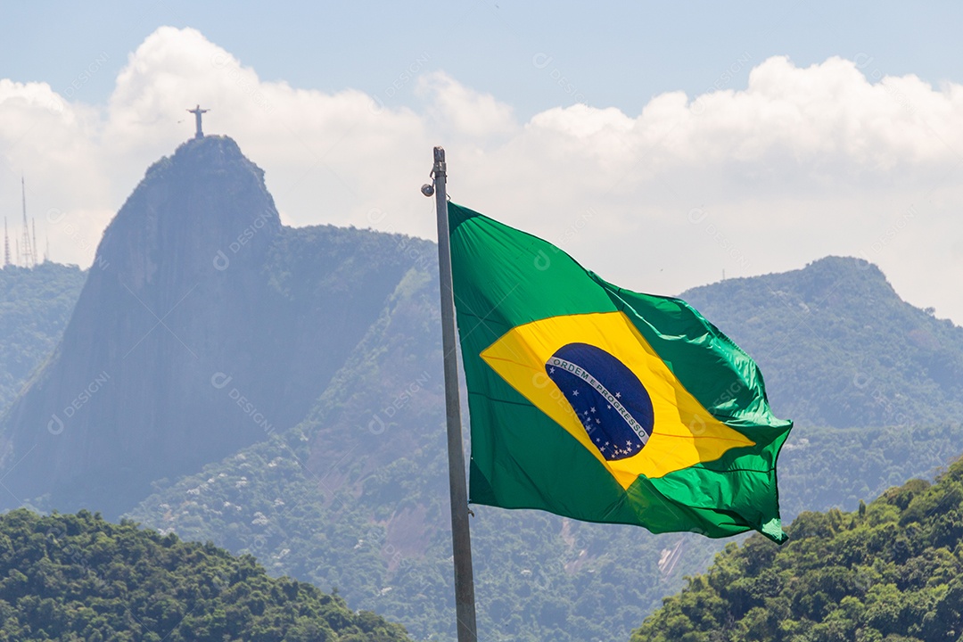 bandeira do brasil com imagem de cristo redentor ao fundo no rio de janeiro brasil.